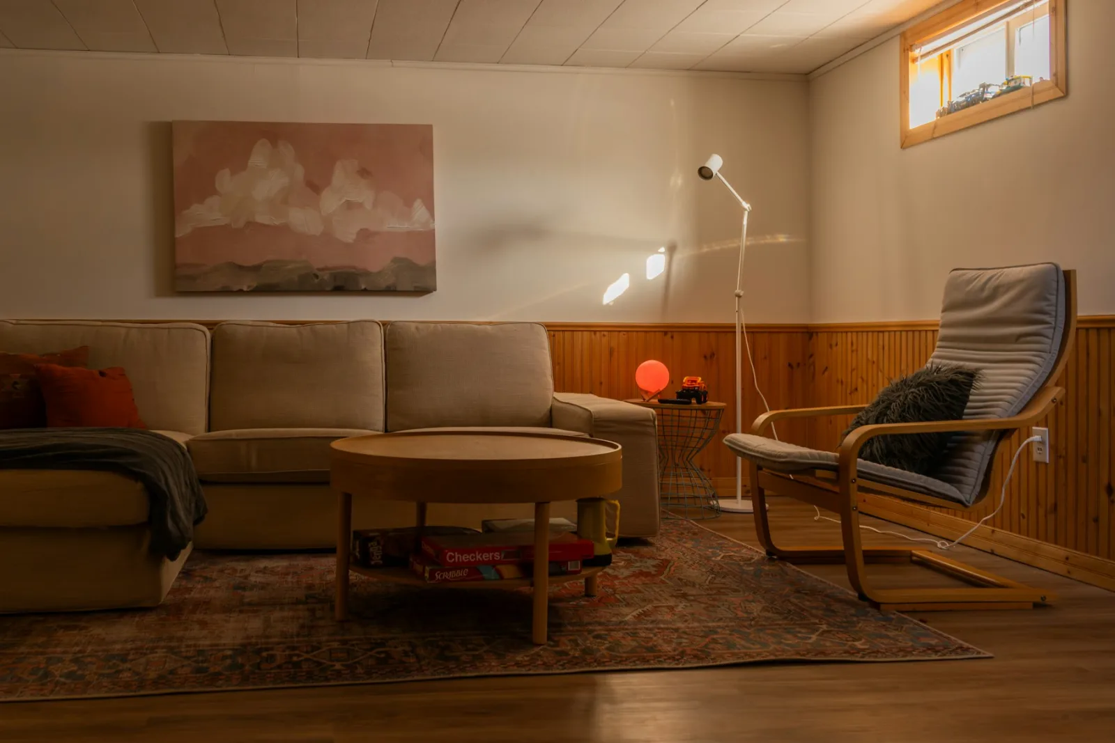 Salon en fin de journée éclairé par plusieurs lampes basses et un lampadaire liseuse