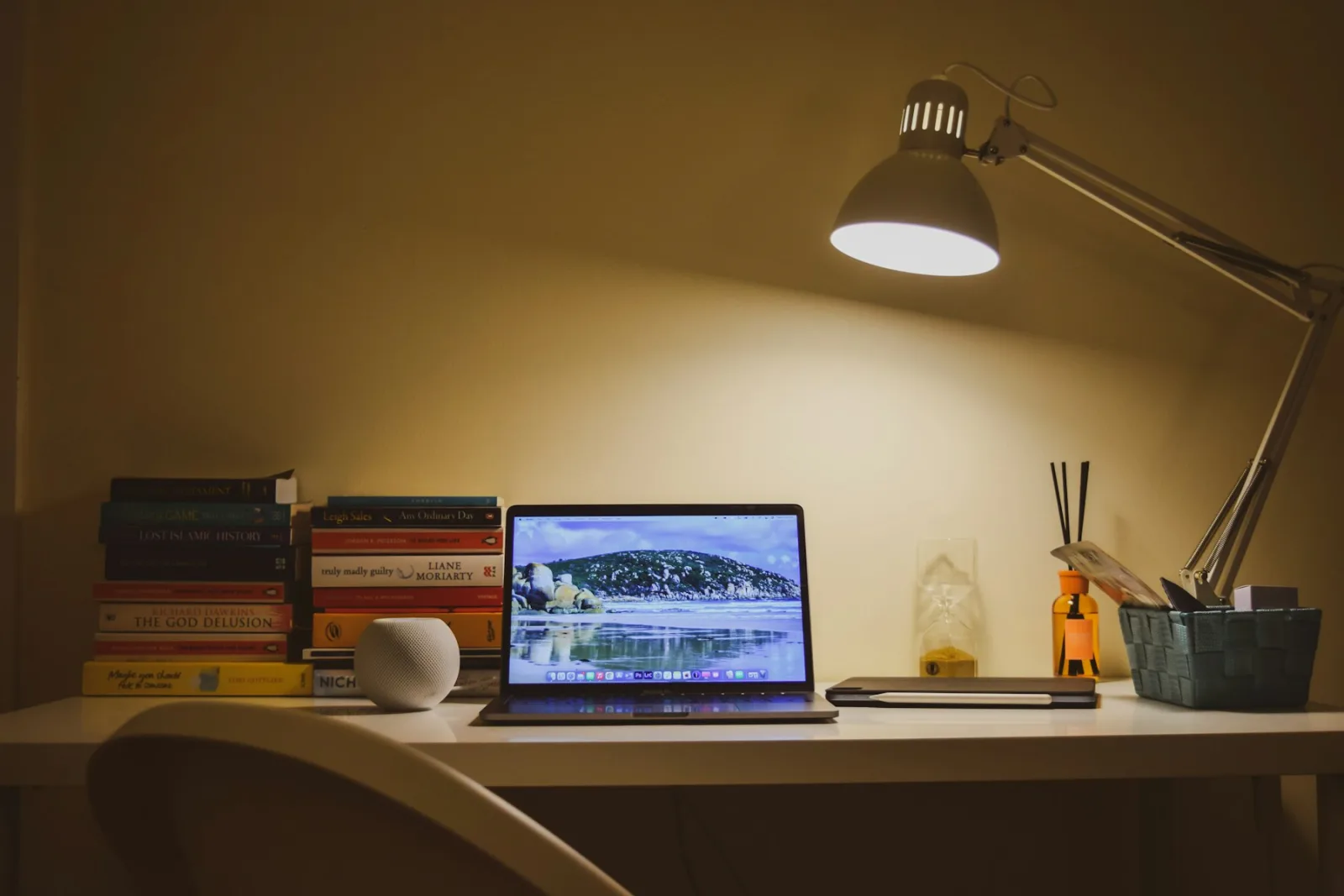 Lampe de bureau orientable allumée le soir au-dessus d'un ordinateur portable