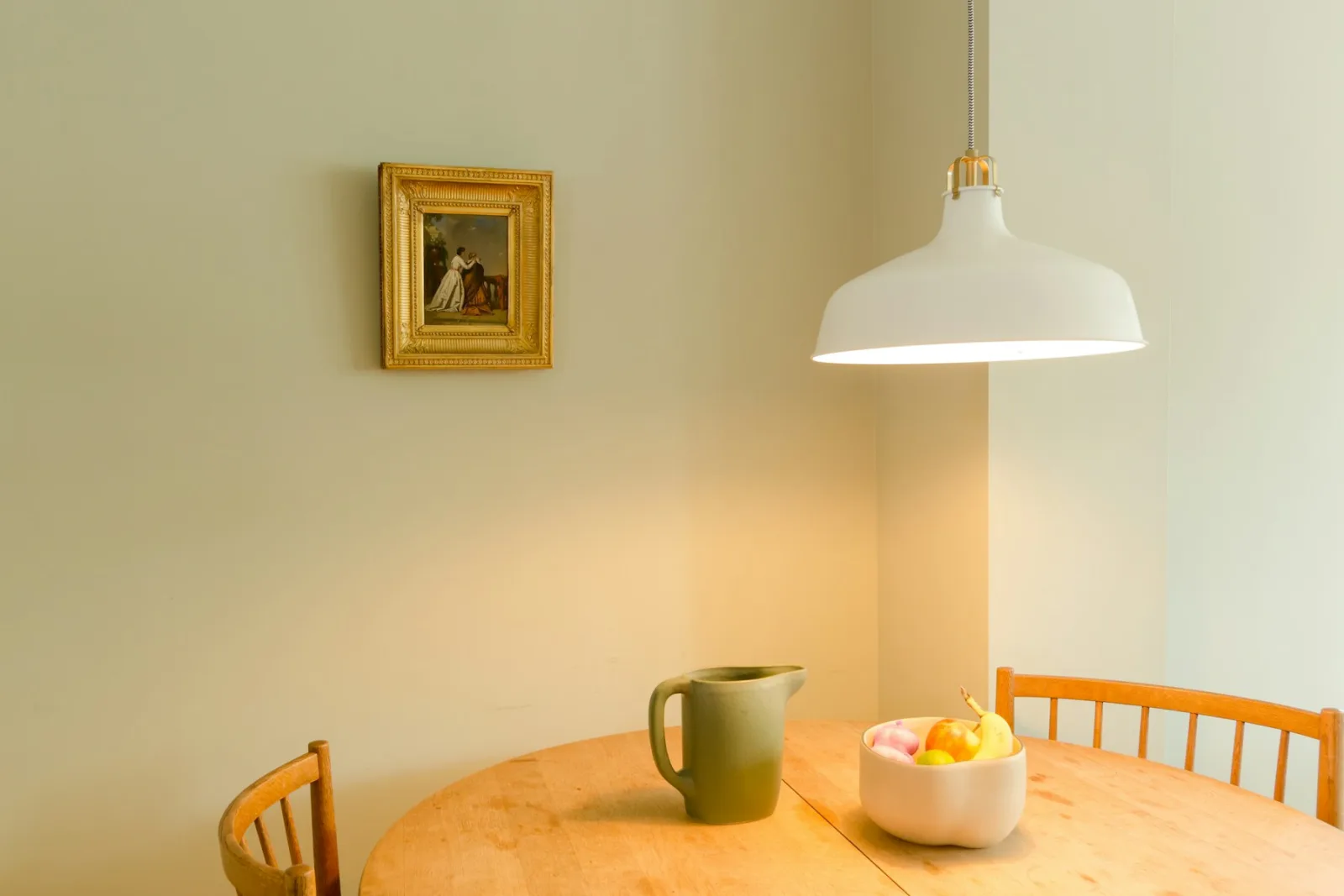 Suspension blanche au-dessus d'une petite table ronde en bois