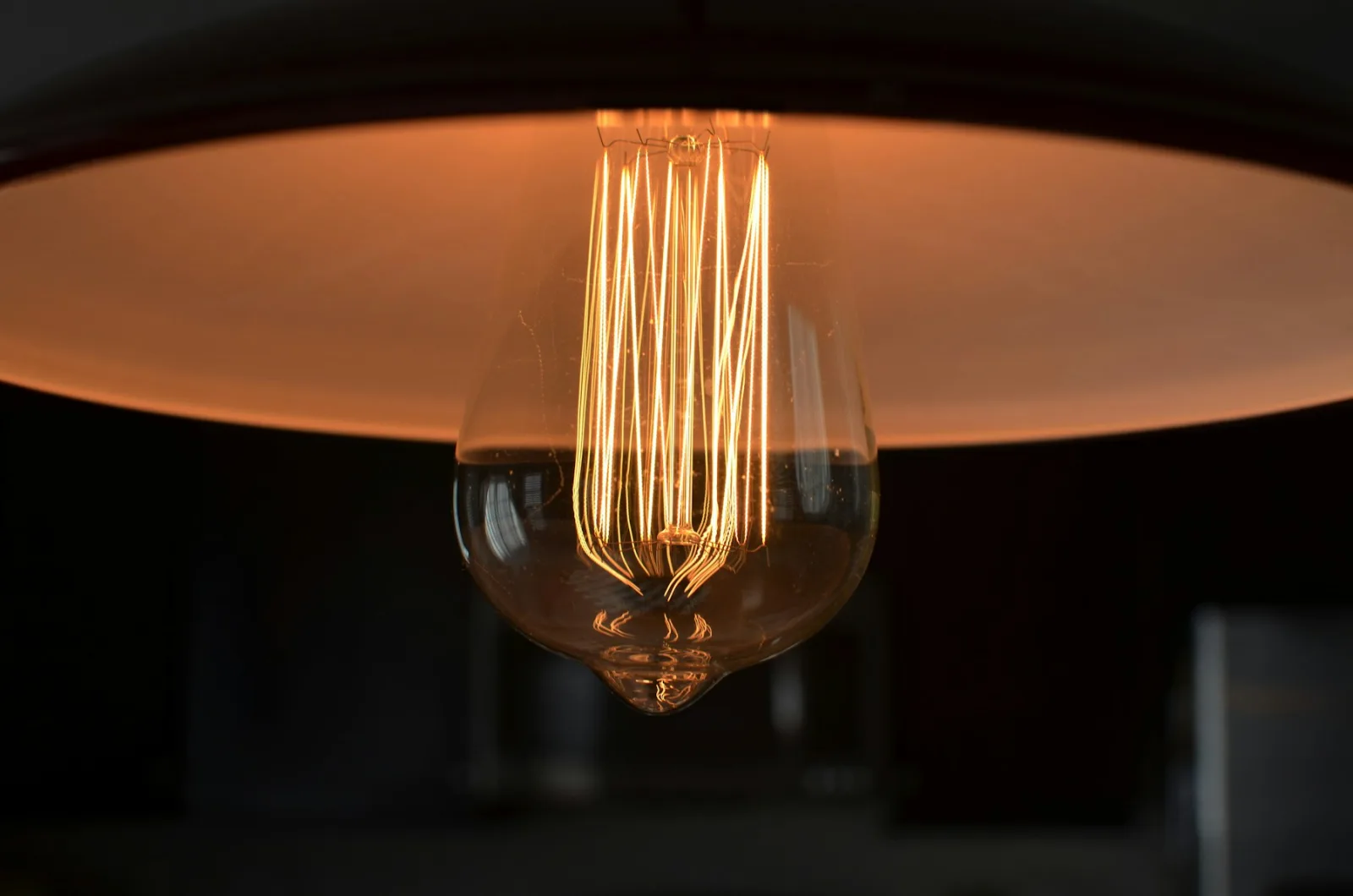 Ampoule à filament visible sous un abat-jour de suspension
