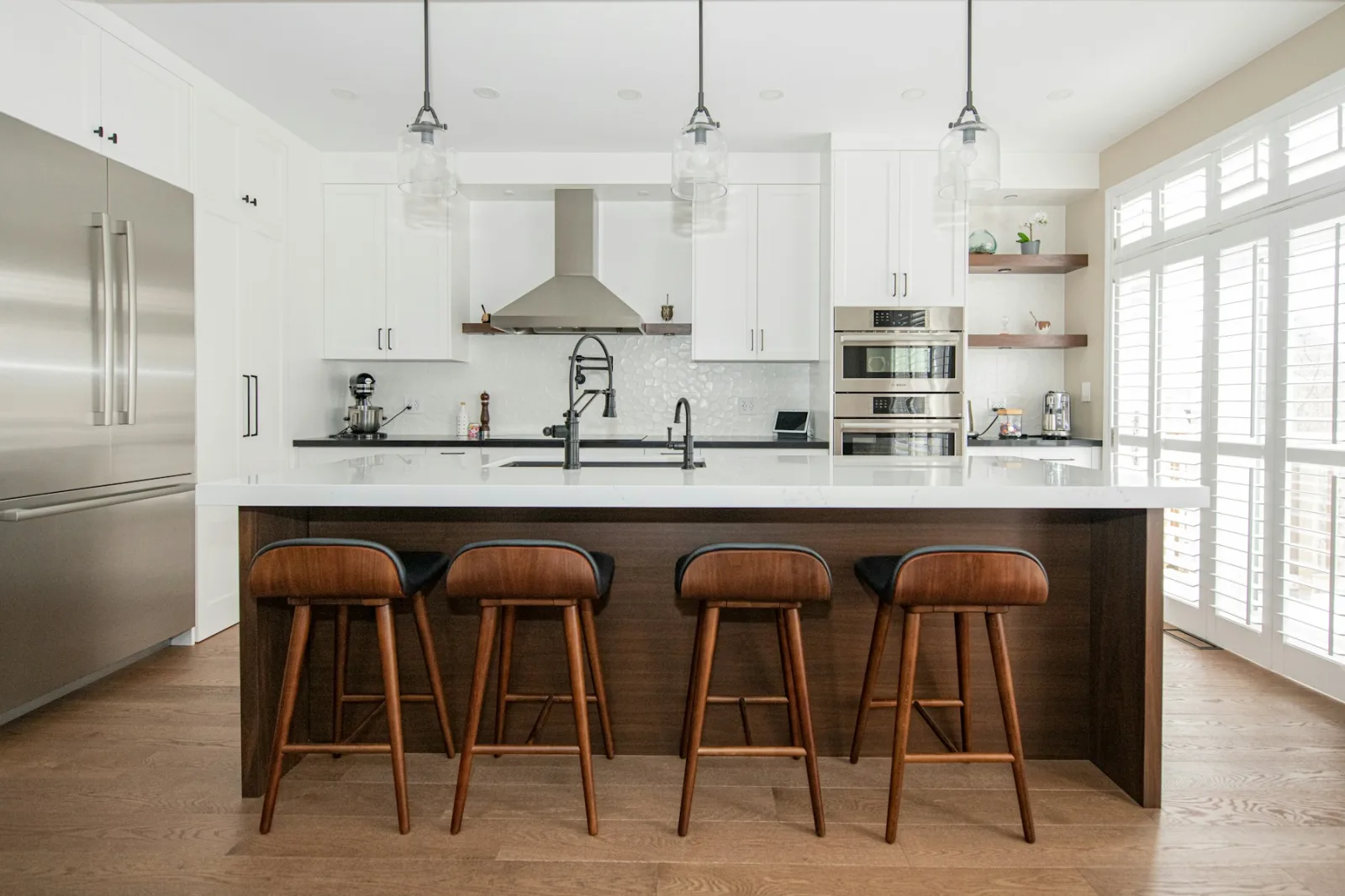 Îlot de cuisine blanc avec quatre tabourets de bar en bois à dossier