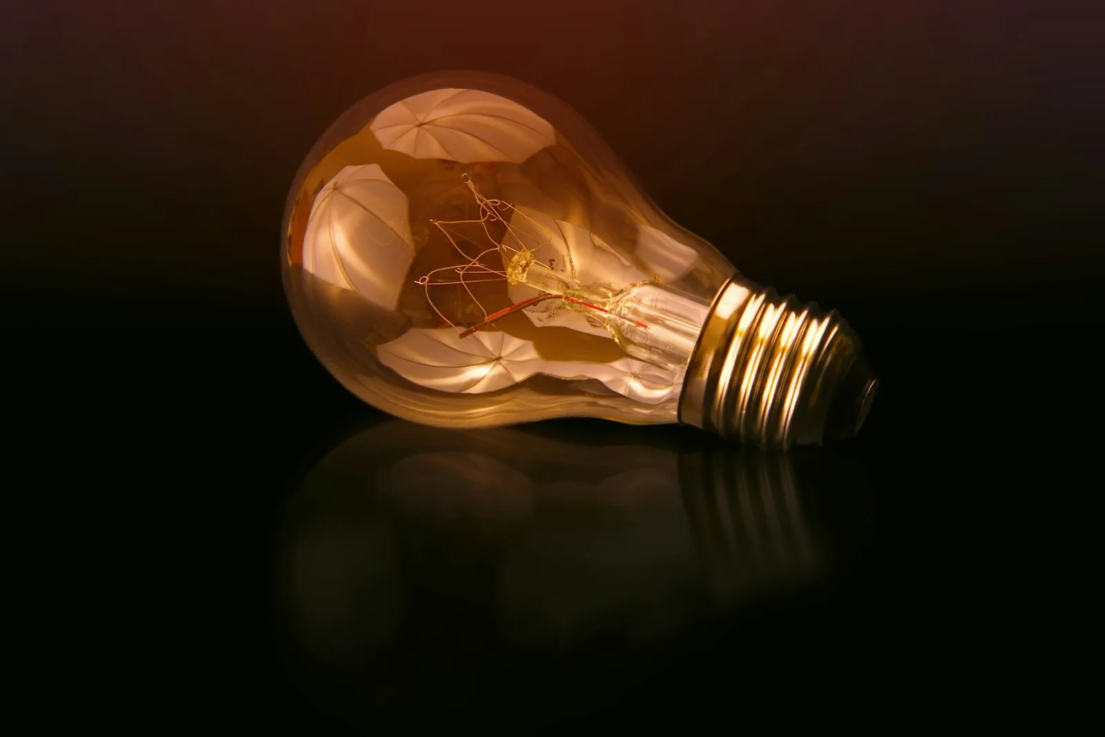 Ampoule à filament ambrée posée sur une surface sombre