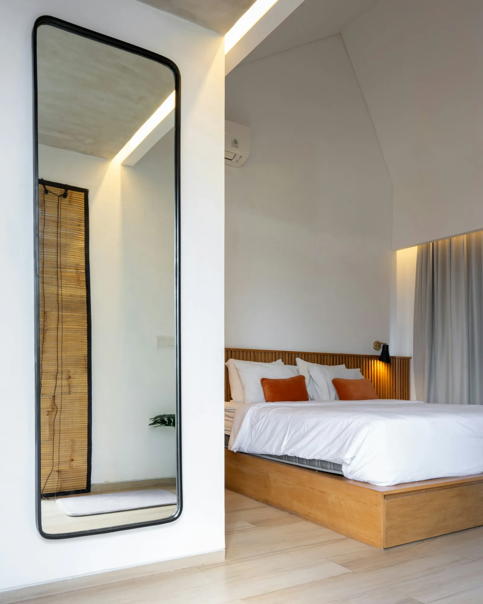 Grand miroir sur pied dans une chambre, posé contre le mur