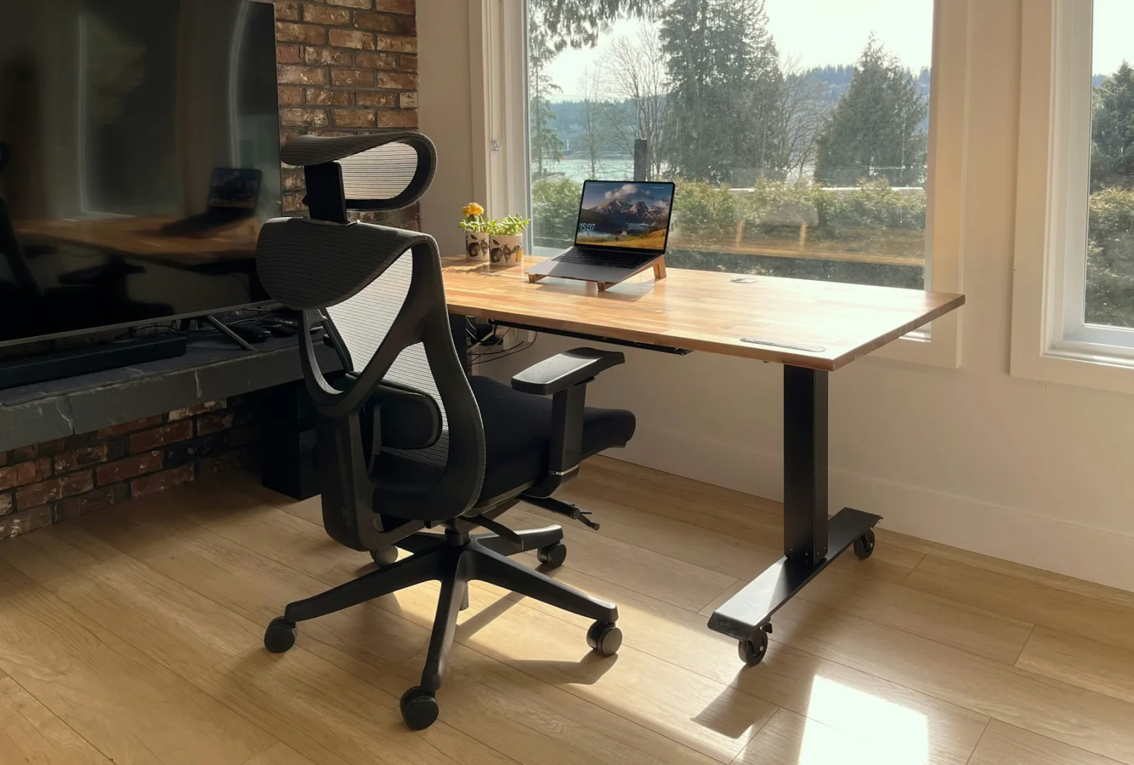 Fauteuil de bureau ergonomique devant un bureau assis-debout près d'une fenêtre