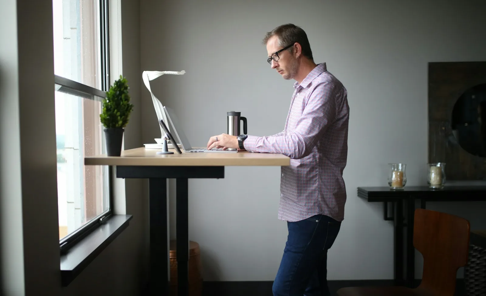 Homme qui travaille debout à un bureau réglable en hauteur