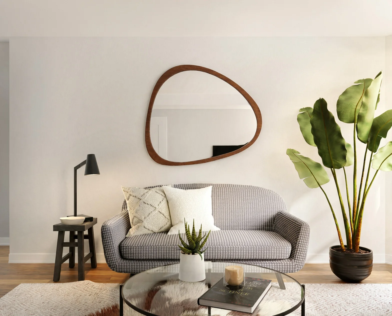 Miroir aux formes organiques au-dessus d'un canapé gris