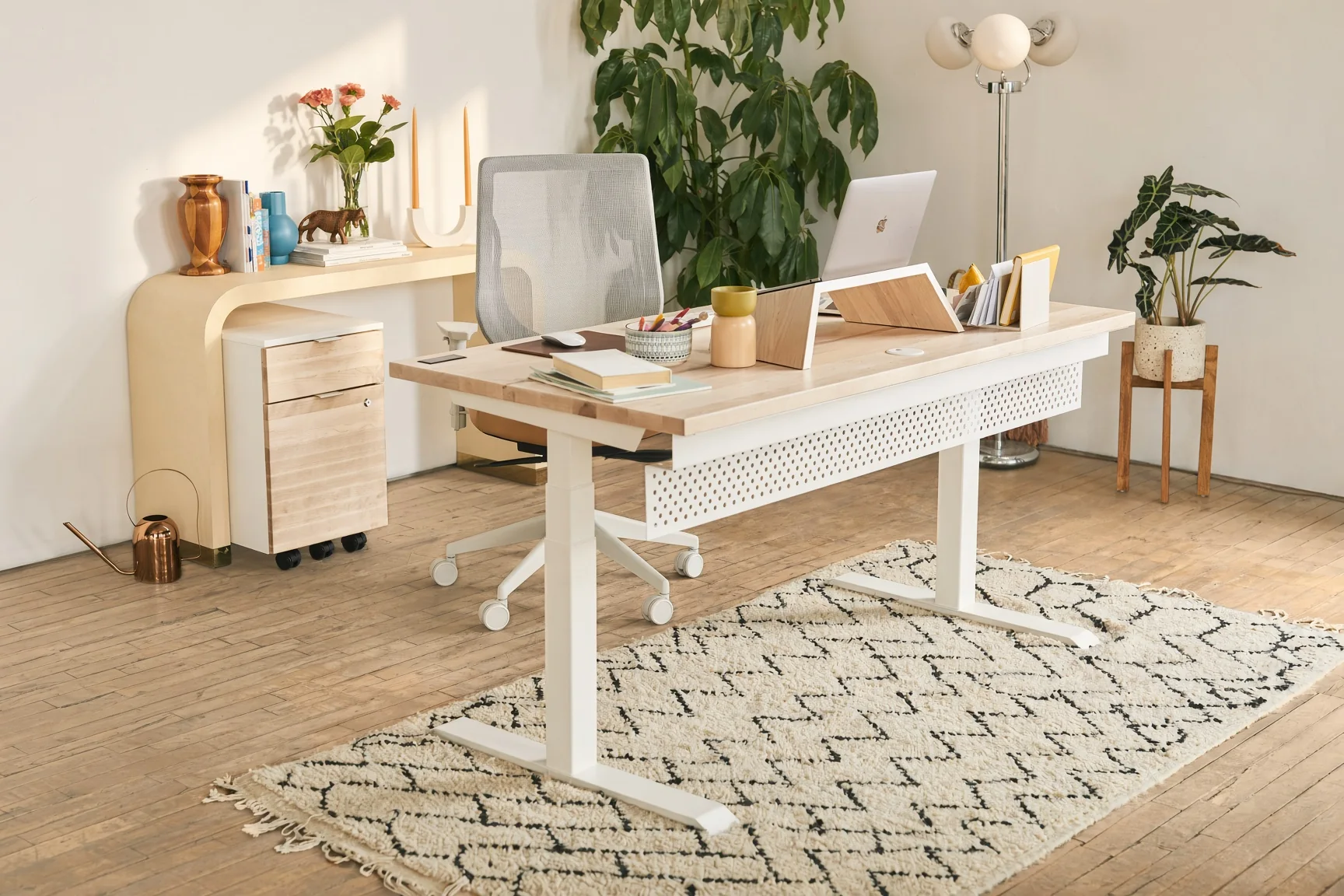 Bureau assis-debout blanc sur un tapis berbère, près d'une fenêtre