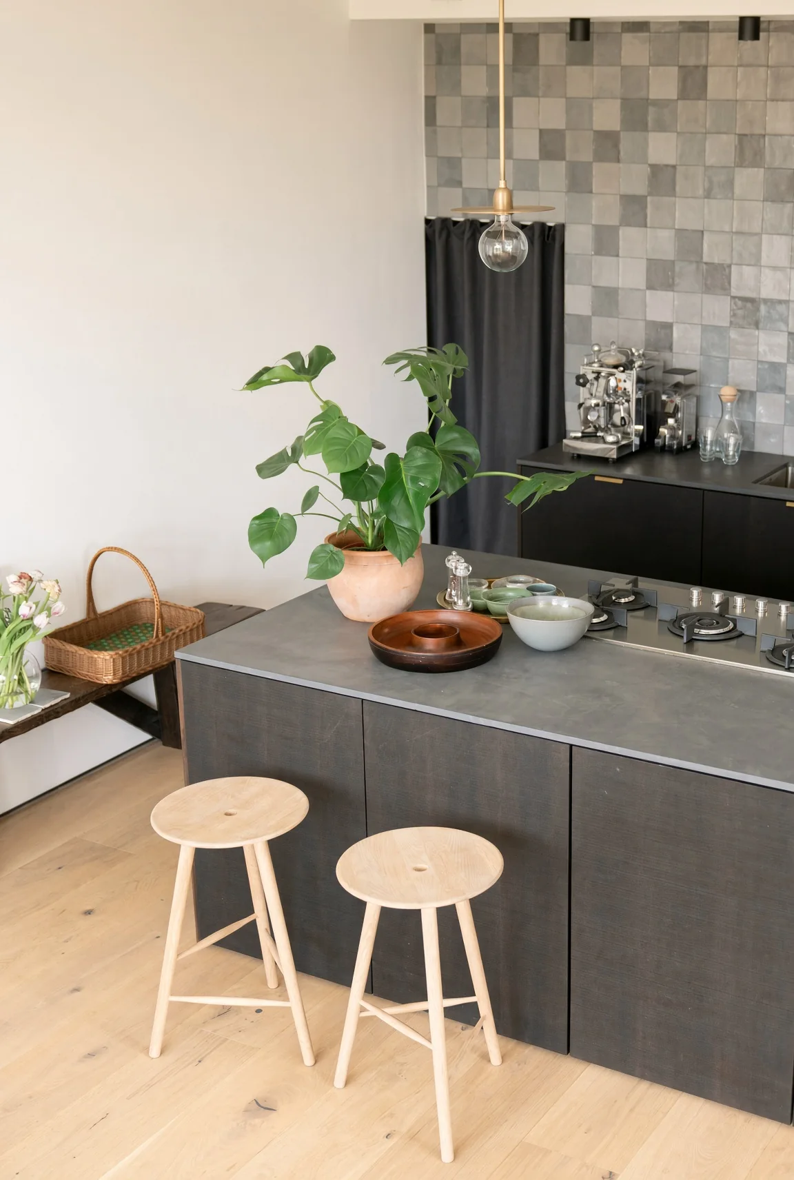 La cuisine : deux tabourets en bois devant un îlot gris